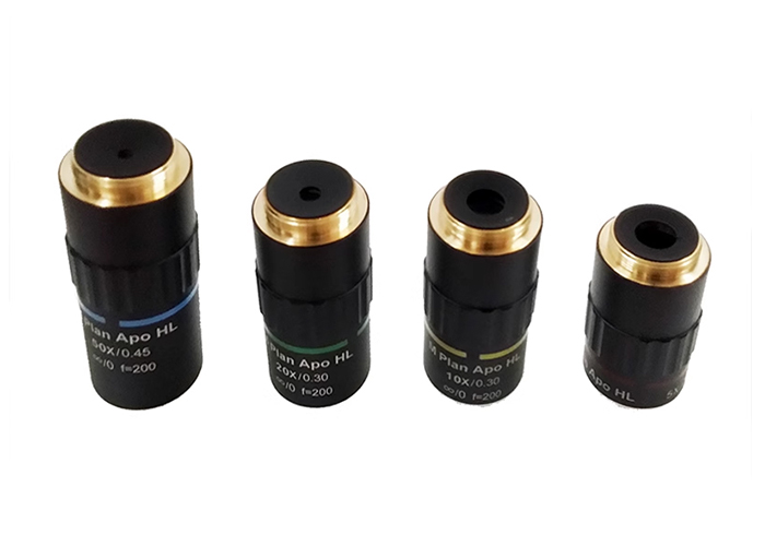 What is the difference between a flat field achromatic objective and a regular achromatic objective?